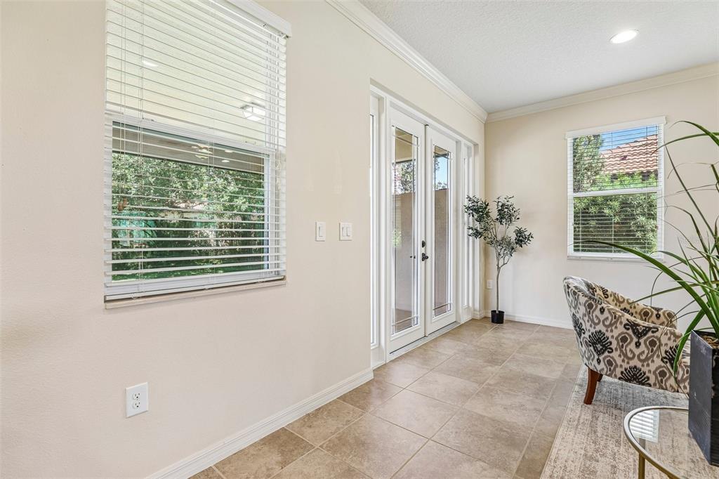 A sunroom features tile flooring, a glass door to the patio, and two windows — 10151 YONAOMI CIRCLE, CLERMONT, FL