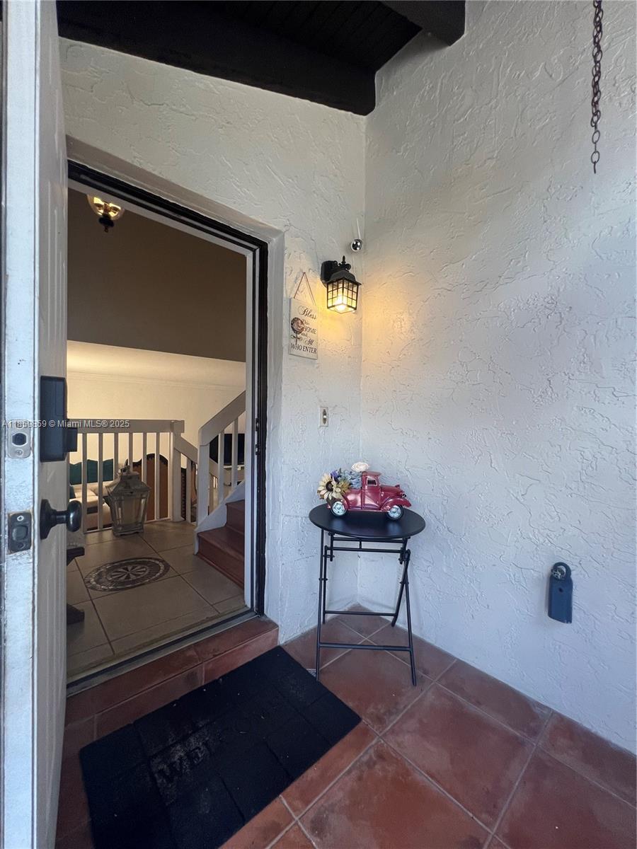 An open front door reveals an interior staircase and tiled entryway from a covered porch — 4910 SW 149th Ct # 11B, Miami FL 33185, MIAMI, FL
