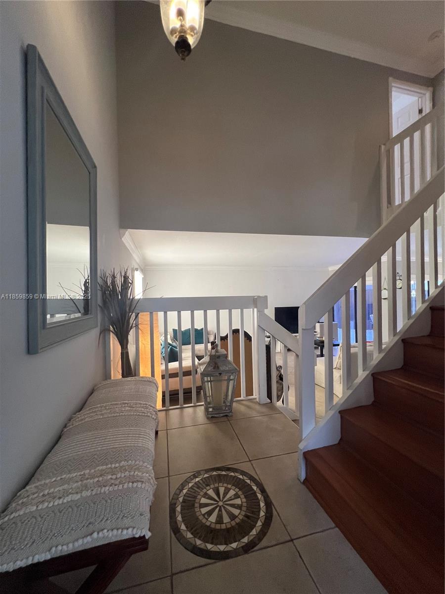 A tiled entryway features a wooden staircase, a bench, and a view into the living room — 4910 SW 149th Ct # 11B, Miami FL 33185, MIAMI, FL