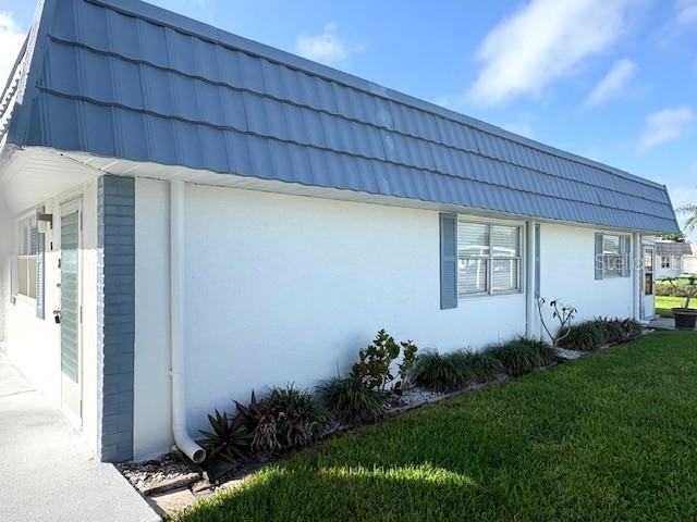 The exterior of a white mobile home features a blue metal roof and blue shutters — 1901 ANDOVER WAY UNIT 38, SUN CITY CENTER, FL
