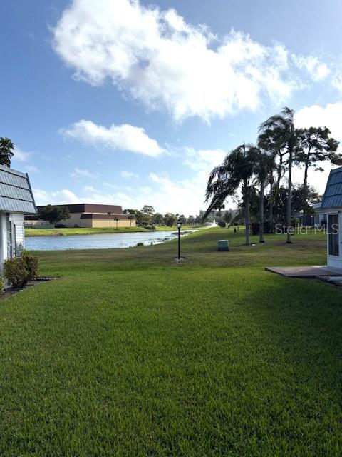 A grassy lawn leads to a pond with a fountain behind residential buildings — 1901 ANDOVER WAY UNIT 38, SUN CITY CENTER, FL