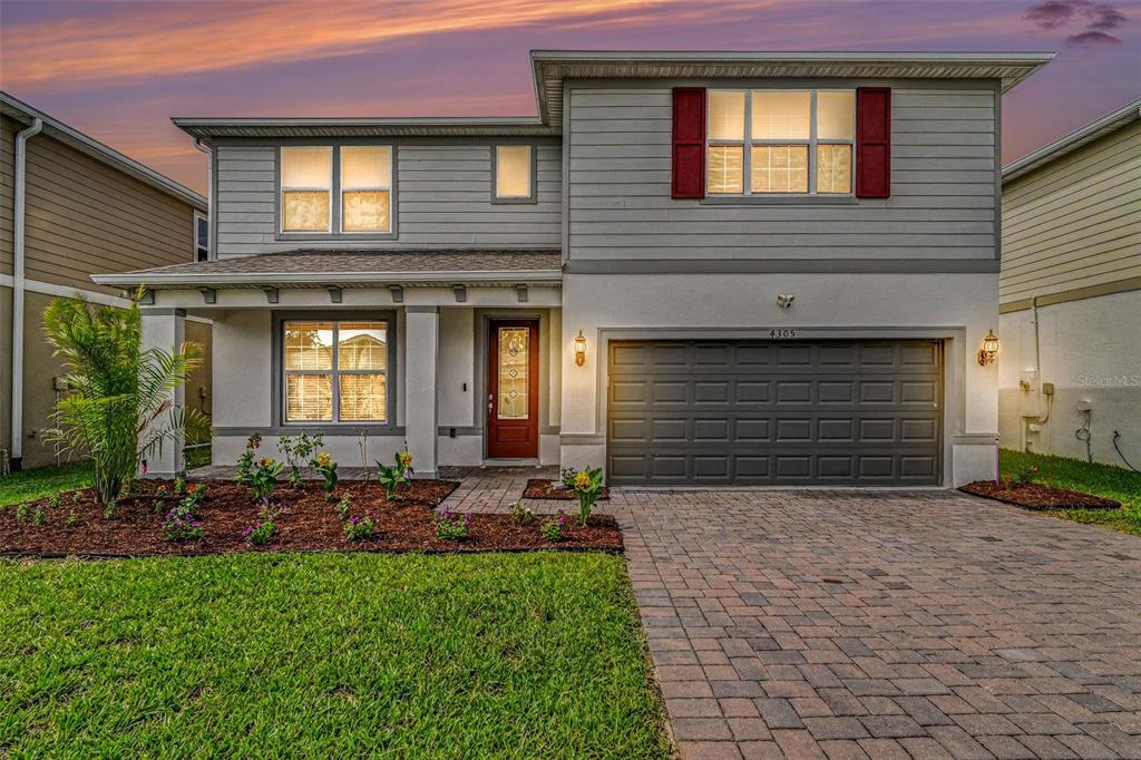 A two-story house with gray siding, a brick driveway, and a front porch — 4305 FOGGY OAK LANE, SANFORD, FL