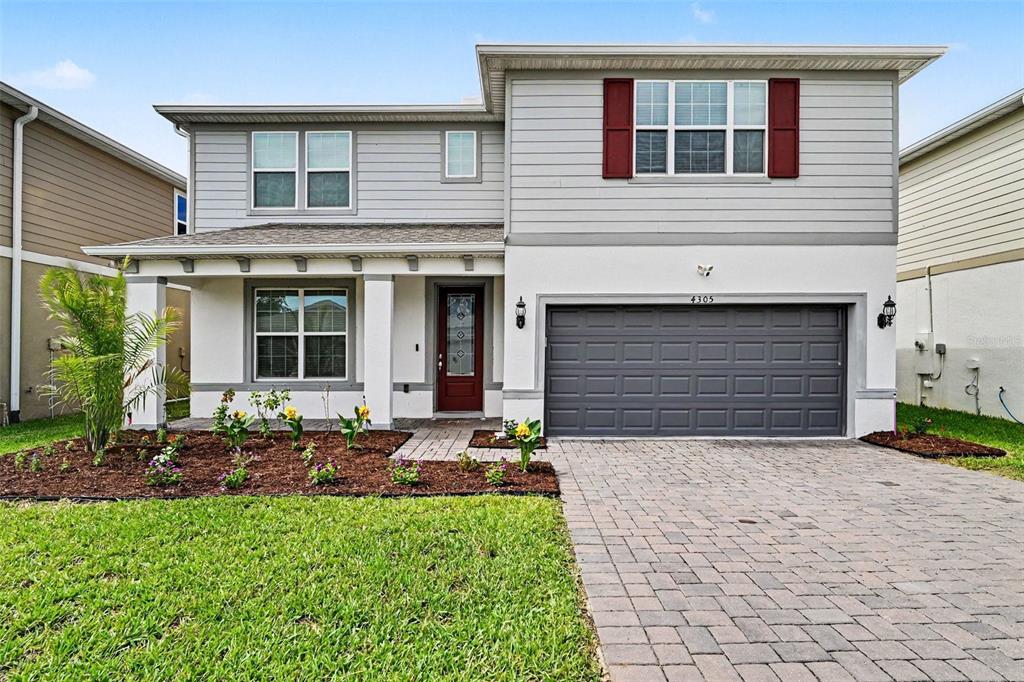 A two-story house with gray siding, a white stucco lower level, and a paved driveway — 4305 FOGGY OAK LANE, SANFORD, FL