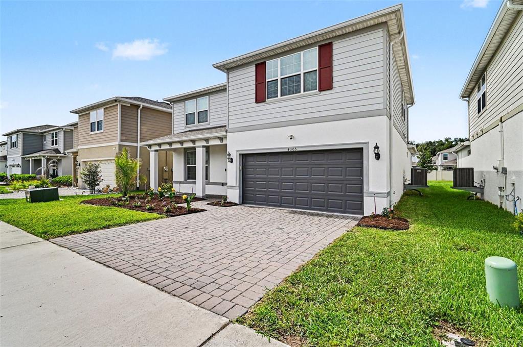 A two-story house with a gray garage, light siding, and a paved driveway — 4305 FOGGY OAK LANE, SANFORD, FL