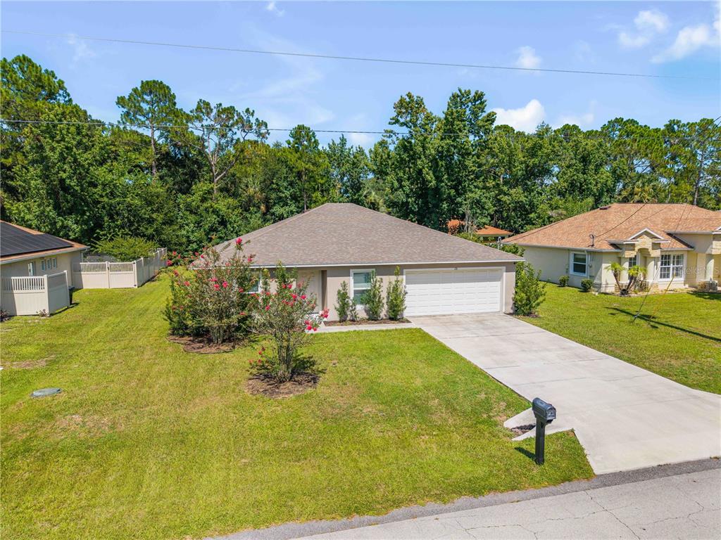 A single-story house with a two-car garage, a concrete driveway, and a front lawn — 176 PINE GROVE DRIVE, PALM COAST, FL