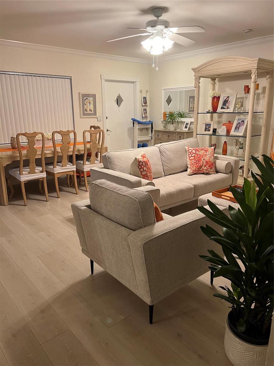 A living room with light wood flooring, a beige sofa, and an adjacent dining area — 2734 NE 27th Court # 22, Lighthouse Point FL 33064, LIGHTHOUSE POINT, FL