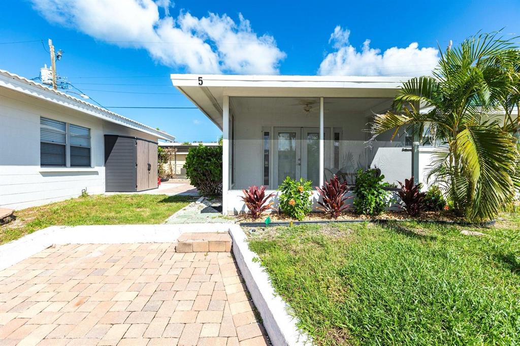 A white house with a screened-in porch, a paved patio, and a small palm tree — 6020 MIDNIGHT PASS ROAD UNIT 5, SARASOTA, FL