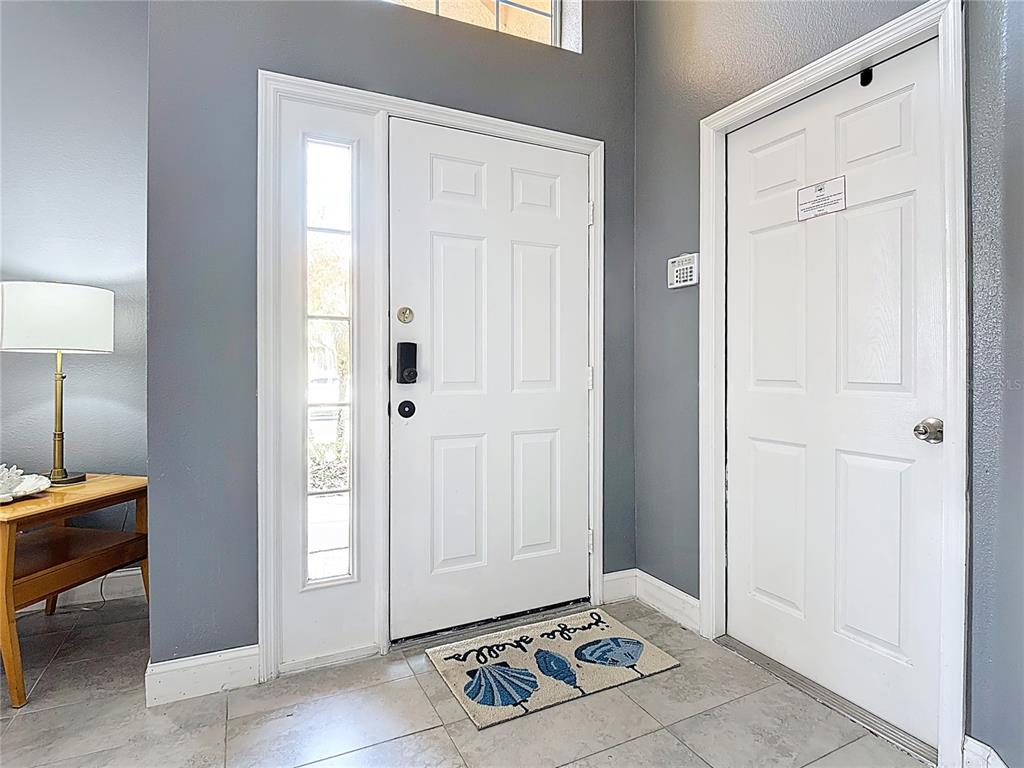 An entryway features gray walls, tile flooring, a white front door, and an adjacent door — 168 HIDEAWAY BEACH LANE, KISSIMMEE, FL