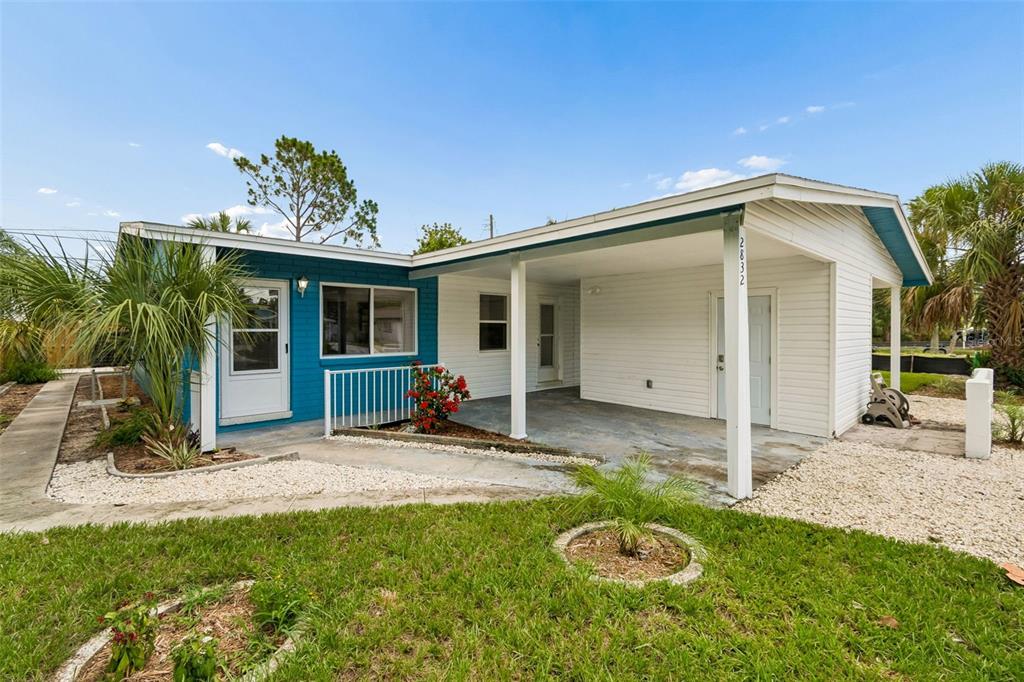 A one-story house with a blue-painted section, white siding, and a covered carport entrance — 2832 MIRIAM STREET S, ST PETERSBURG, FL