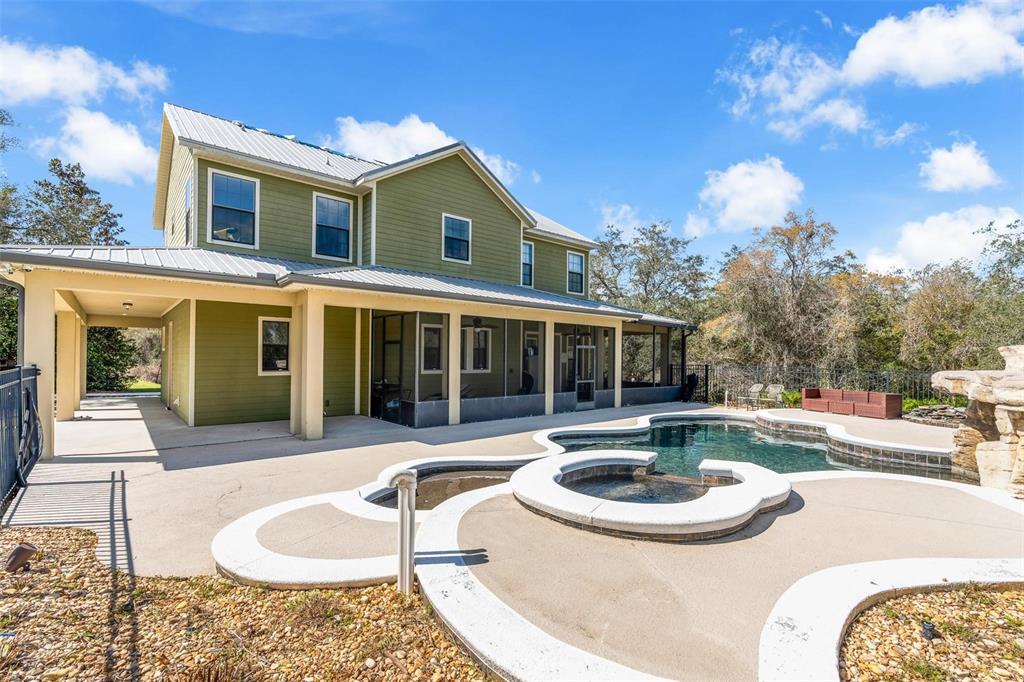 A two-story green house with a metal roof, screened porch, and an outdoor swimming pool — 326 ENTERPRISE OSTEEN ROAD, OSTEEN, FL