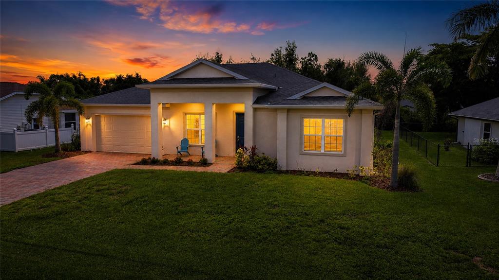 A single-story house with a beige stucco exterior, a two-car garage, and a paved driveway — 7442 S BLUE SAGE, PUNTA GORDA, FL