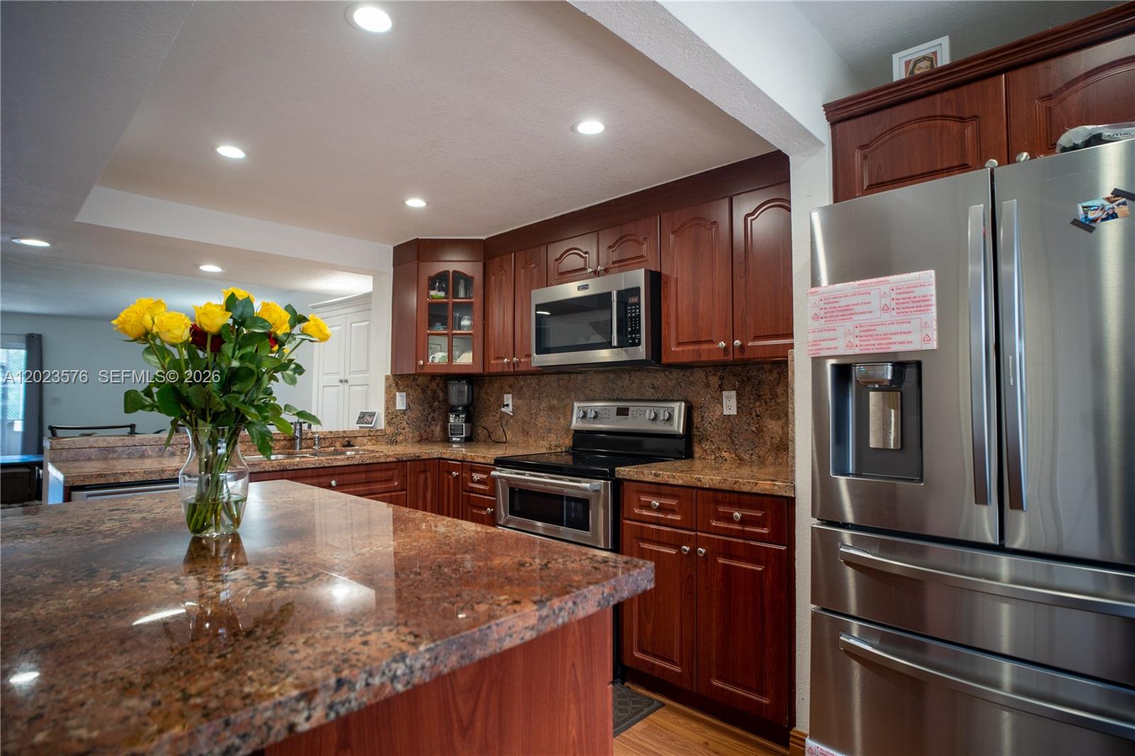 A kitchen features cherry wood cabinets, granite countertops, stainless steel appliances, and a central island — 10052 NW 41st St # 5, Doral FL 33178, DORAL, FL