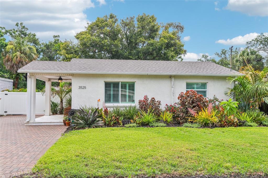 A single-story house with a white stucco exterior, a covered porch, and a landscaped yard — 3525 W PAUL AVENUE, TAMPA, FL