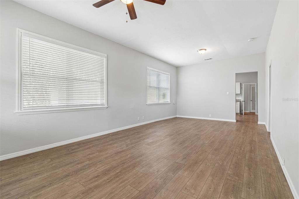 A covered front porch features beige siding, a white door, and a concrete floor — 1522 E 21ST AVENUE, TAMPA, FL