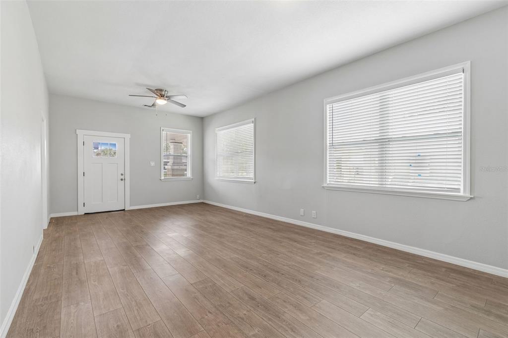 A covered front porch with white railings and brick columns overlooks a residential street — 1522 E 21ST AVENUE, TAMPA, FL