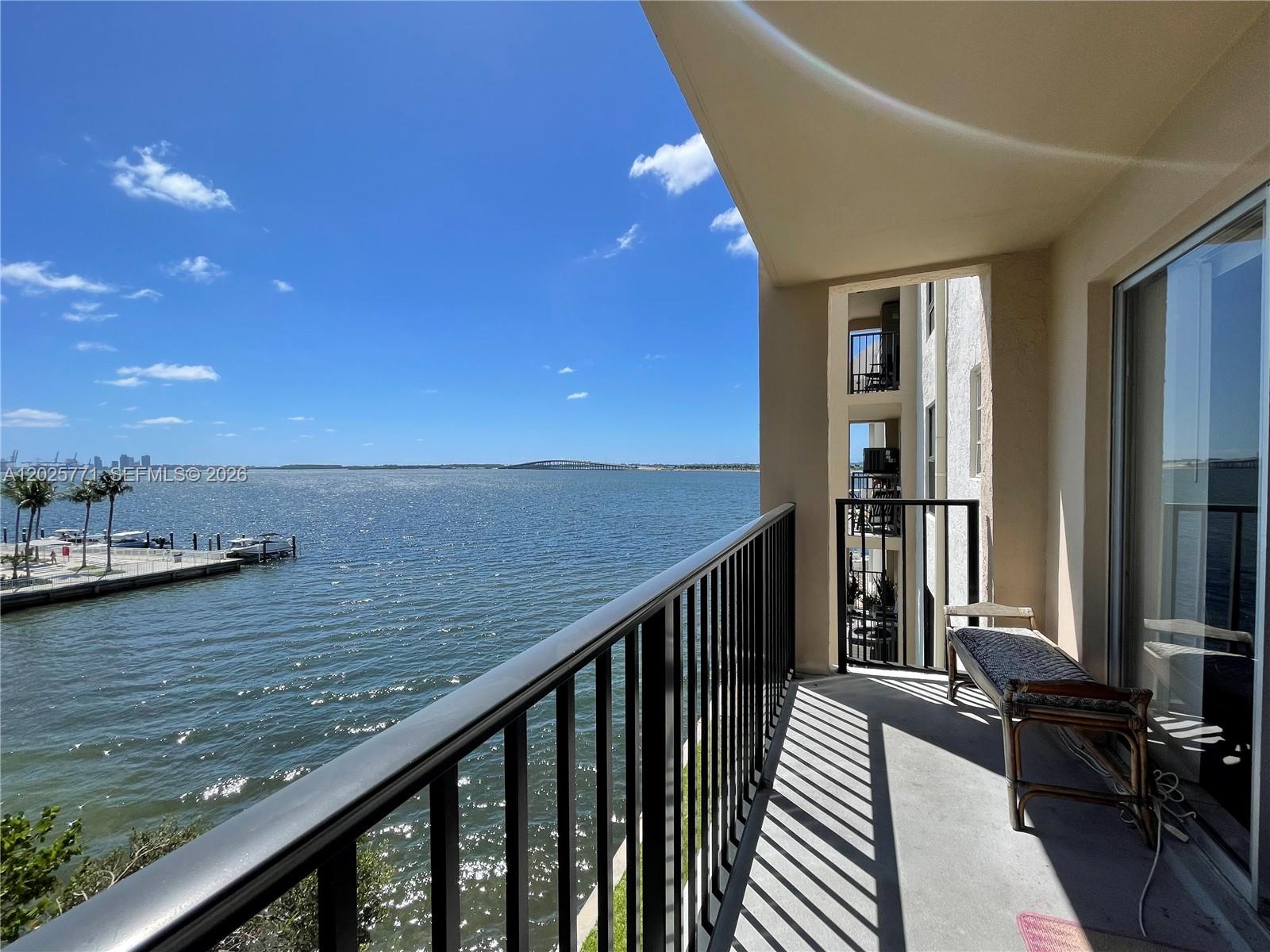 A balcony with a black metal railing overlooks a large body of water — 2201 Brickell Ave # 73, Miami FL 33129, MIAMI, FL