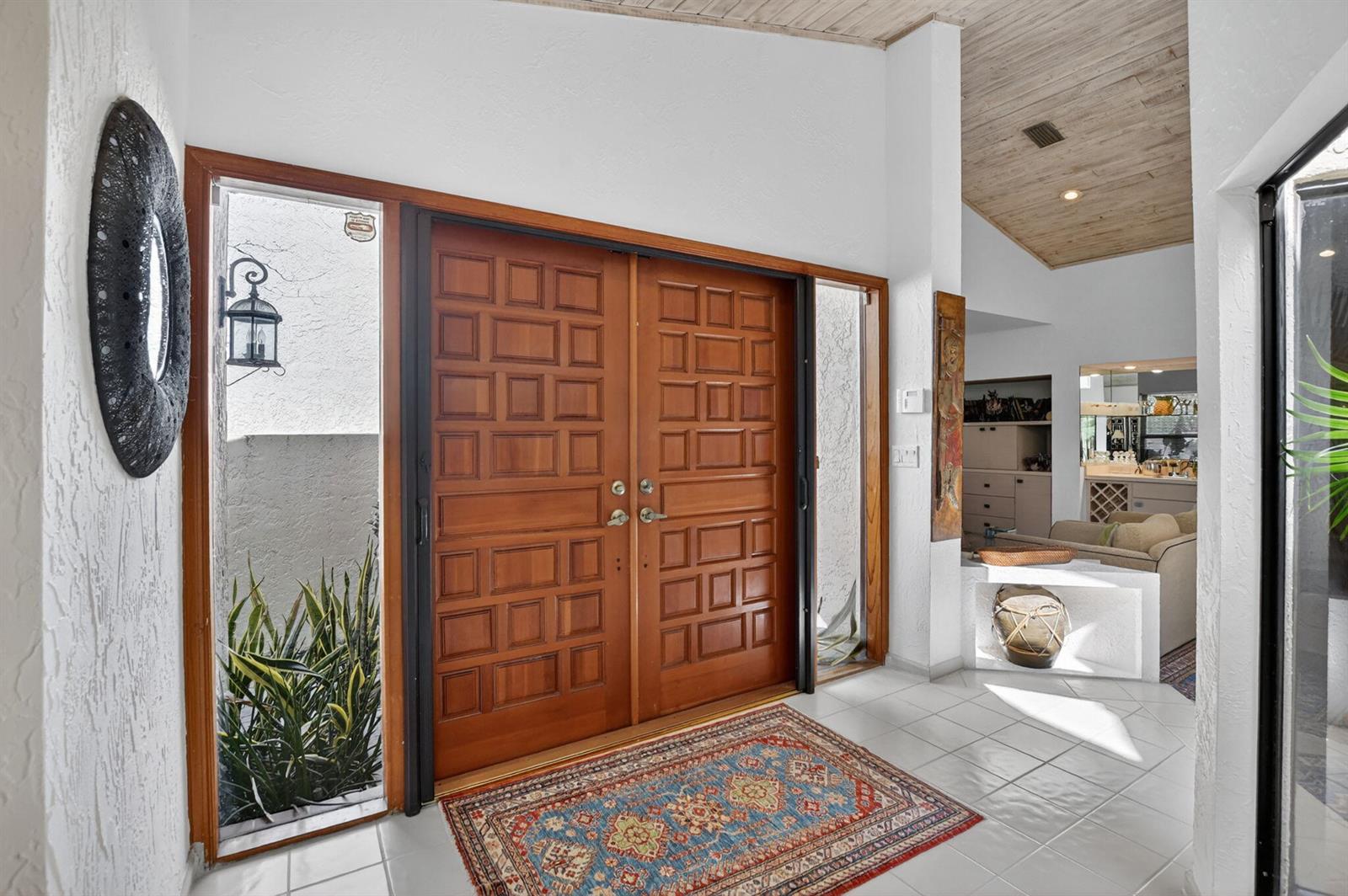 An entryway features double wooden doors with side windows, a patterned rug, and vaulted ceilings — 22519 W Esplanada Cir W, Boca Raton FL 33433, BOCA RATON, FL