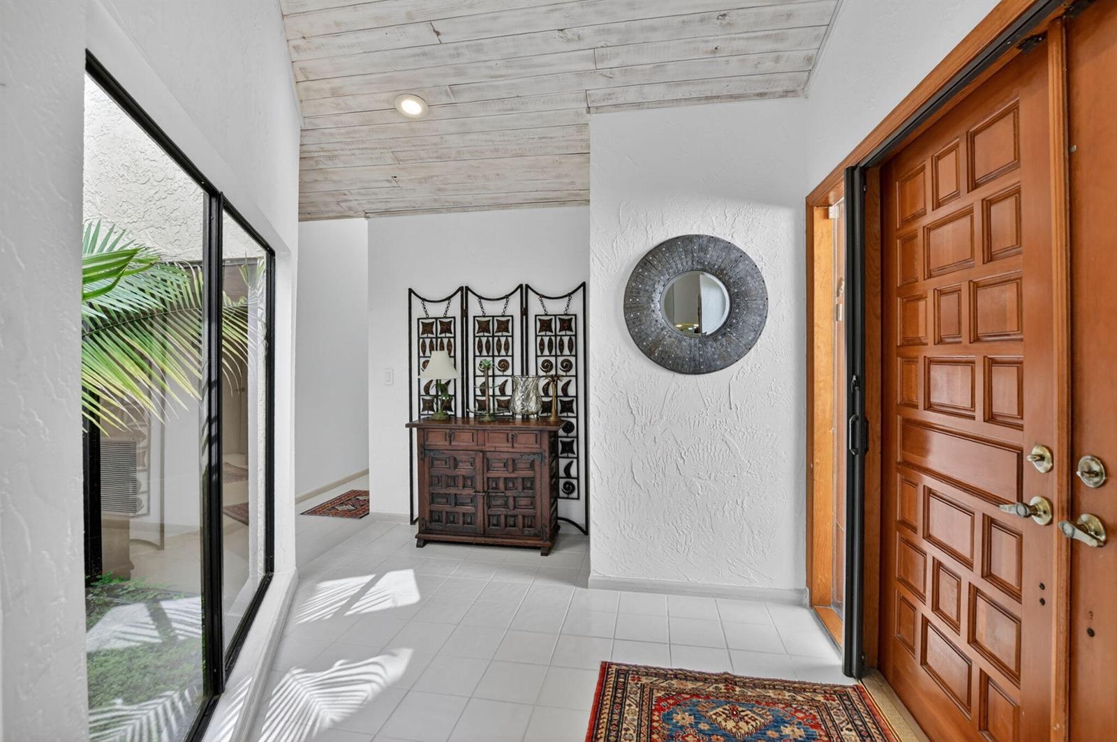 An entryway features white tile floors, a wooden door, a textured wall, and a wood-plank ceiling — 22519 W Esplanada Cir W, Boca Raton FL 33433, BOCA RATON, FL