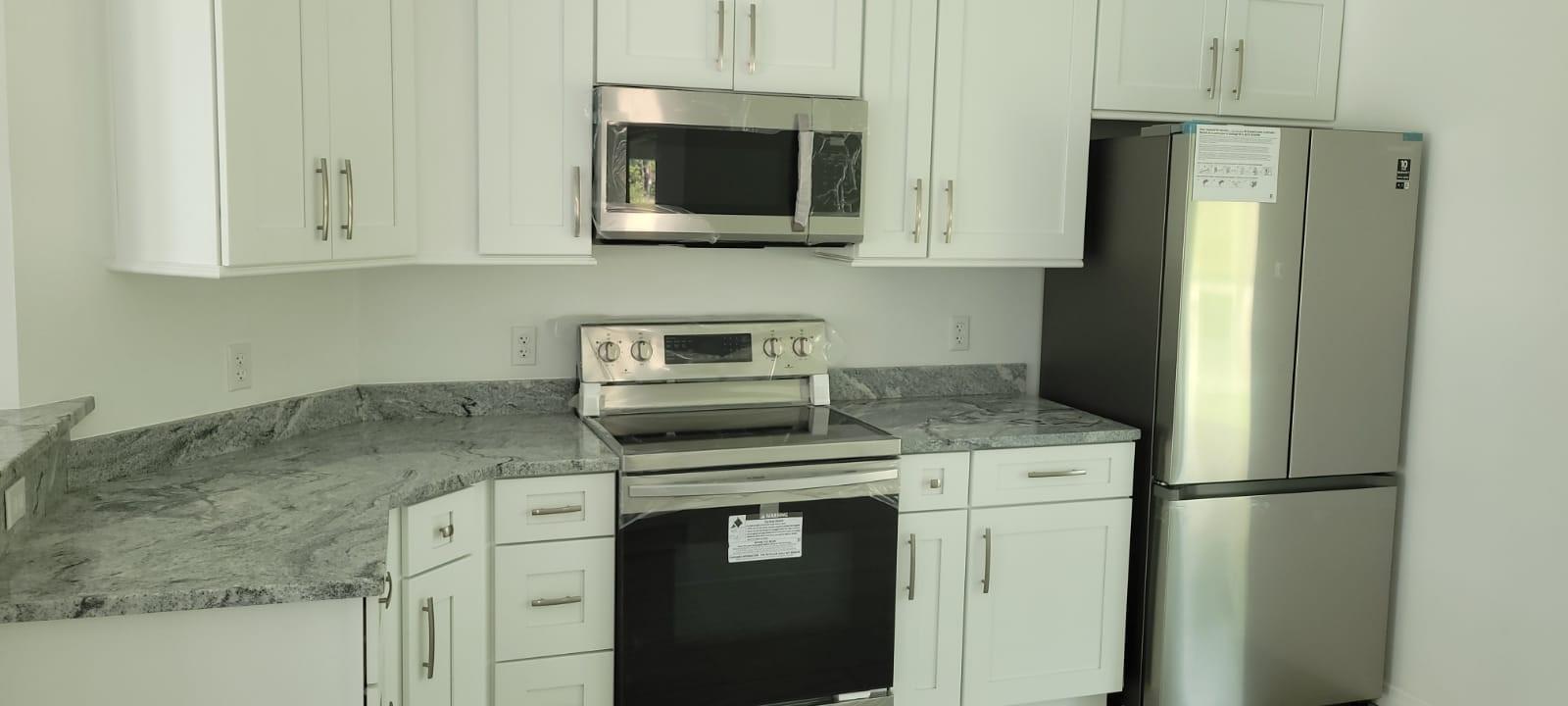 A kitchen features white cabinets, granite countertops, and stainless steel appliances — 14429 36th Avenue, FL 34491, FL