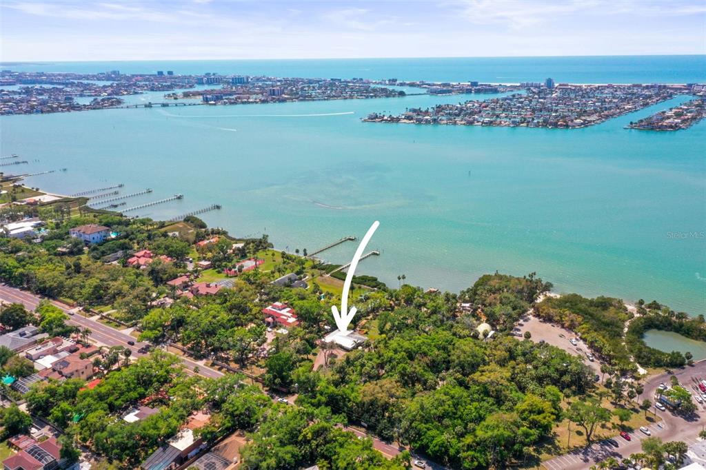 An aerial view shows a house surrounded by trees near a large body of water — 1600 PARK STREET N, ST PETERSBURG, FL