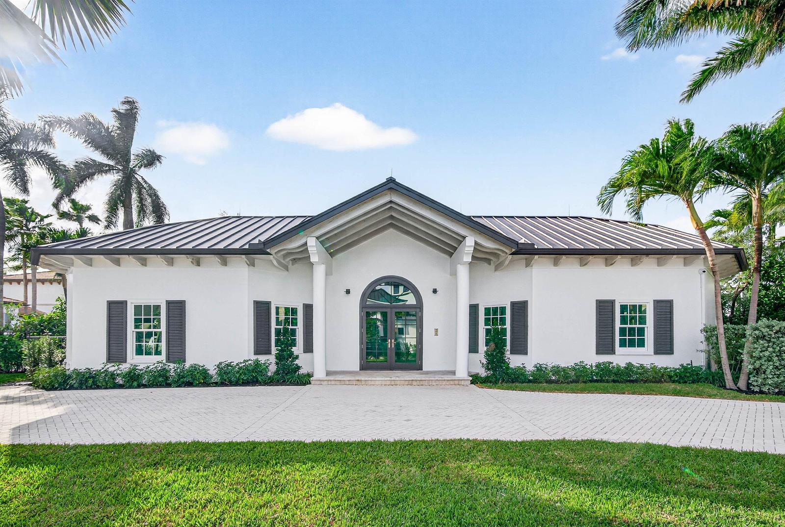 A single-story white house with a metal roof, arched entryway, and a paved driveway — 720 N Ocean Boulevard, Delray Beach FL 33483, DELRAY BEACH, FL