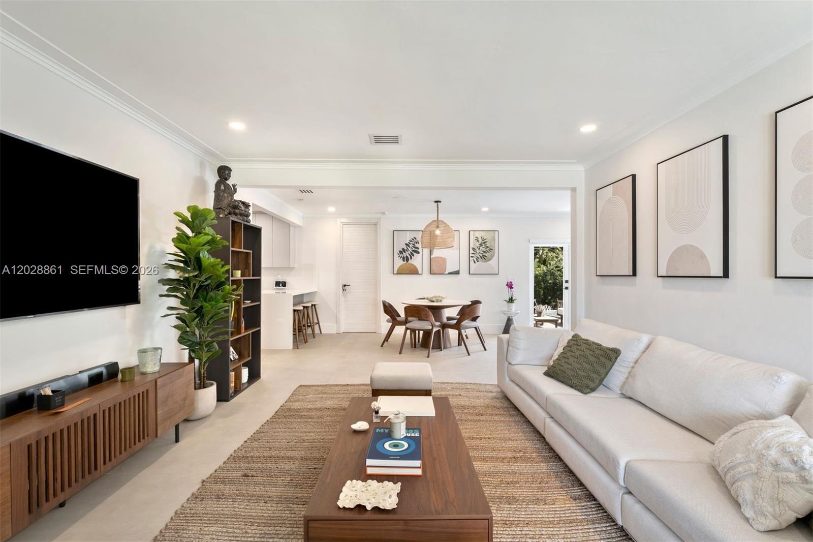A living room with a white sofa, wooden coffee table, and an adjacent dining area — 45 Palermo Ave, Coral Gables FL 33134, CORAL GABLES, FL