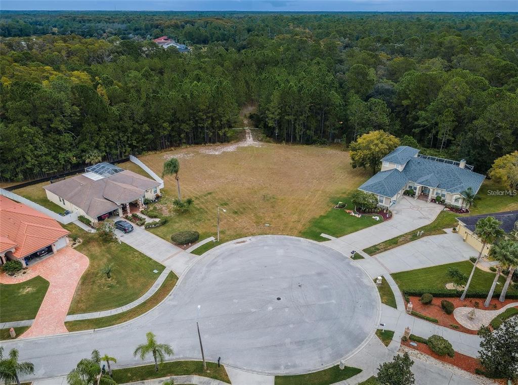 An aerial view shows a vacant residential lot situated between two houses in a cul-de-sac — 0 SHOOTING STAR COURT, NEW PORT RICHEY, FL