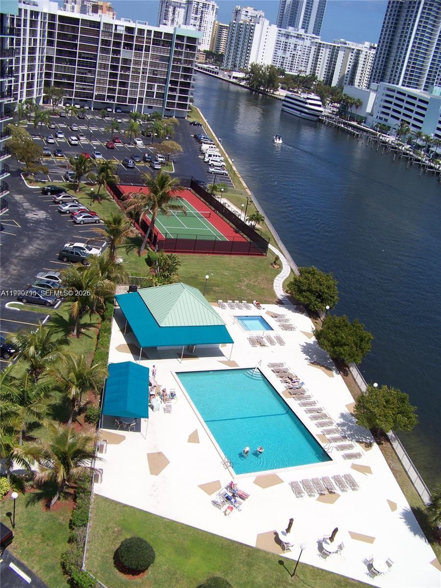 A kitchen counter overlooks a dining area and living room with a balcony view — 200 Leslie Dr # 425, Hallandale Beach FL 33009, HALLANDALE BEACH, FL