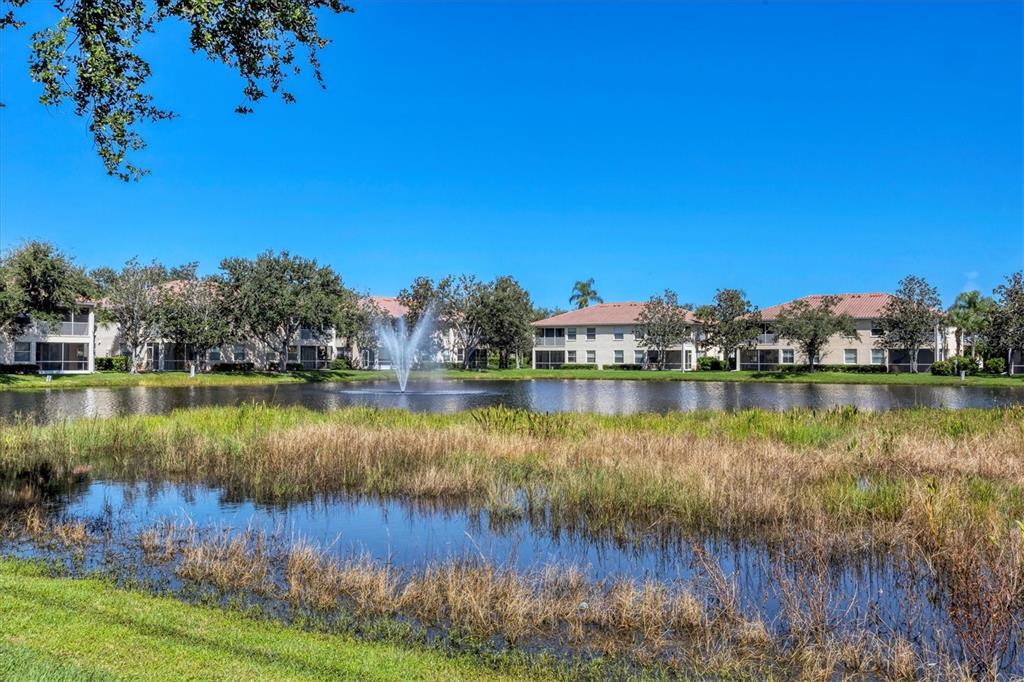 An aerial view shows multi-story residential buildings with tile roofs and detached garages — 4206 VICENZA DRIVE UNIT C24, VENICE, FL