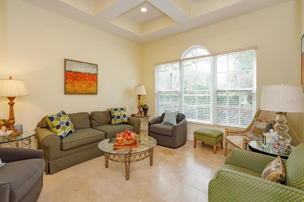 A living room features a tray ceiling, tile flooring, a sofa, and several armchairs — 8920 VIA BELLA NOTTE, ORLANDO, FL