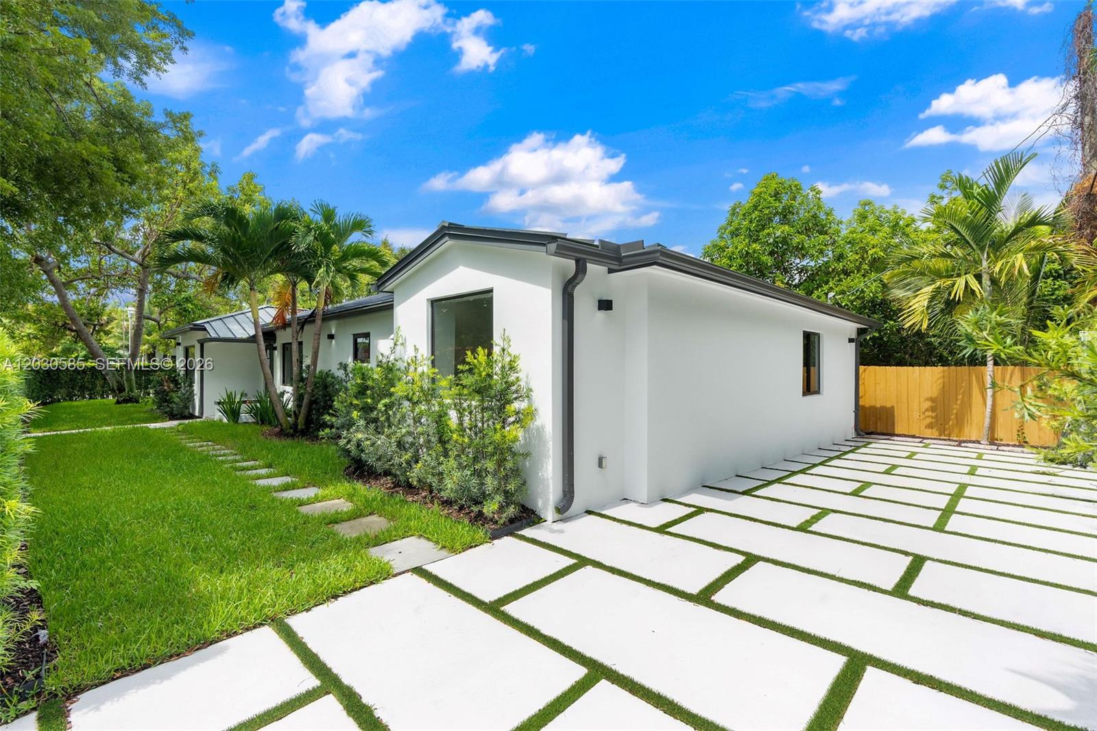 A white house exterior features a paved driveway with grass strips and surrounding palm trees — 2286 SW 21st Ave, Miami FL 33145, MIAMI, FL