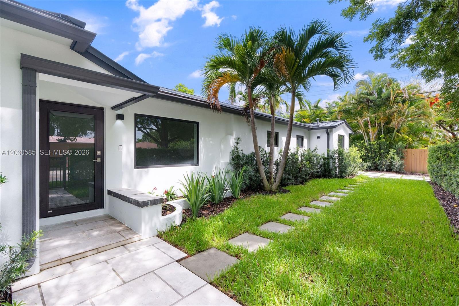 A white house exterior features a glass door, stone walkway, and palm trees on grass — 2286 SW 21st Ave, Miami FL 33145, MIAMI, FL