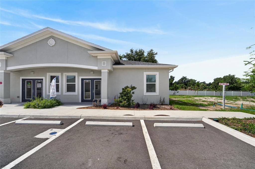 A single-story commercial building with a parking lot and a vacant lot for sale — 730 CACTUS RIDGE CIRCLE UNIT A, SEFFNER, FL