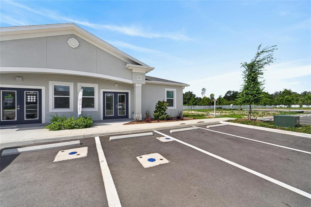 The exterior of a single-story commercial building features gray siding and a paved parking lot — 730 CACTUS RIDGE CIRCLE UNIT A, SEFFNER, FL