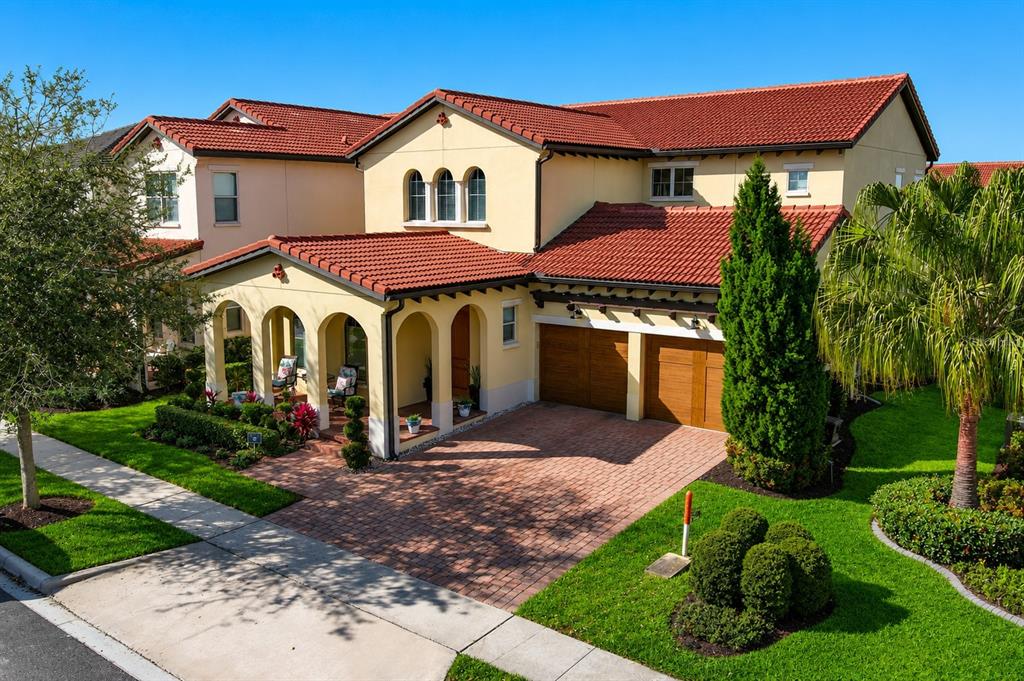 An exterior view of a two-story stucco house with a red tile roof and garage — 15149 CANOE PLACE, WINTER GARDEN, FL
