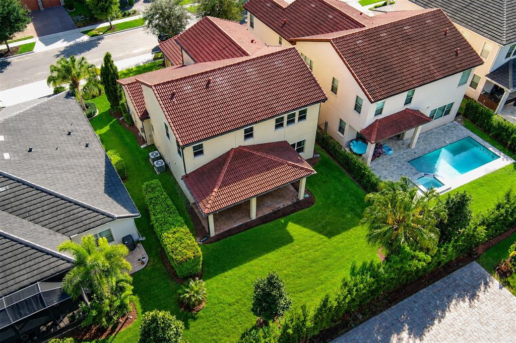 An aerial view shows the backyards and tiled roofs of two suburban houses — 15149 CANOE PLACE, WINTER GARDEN, FL