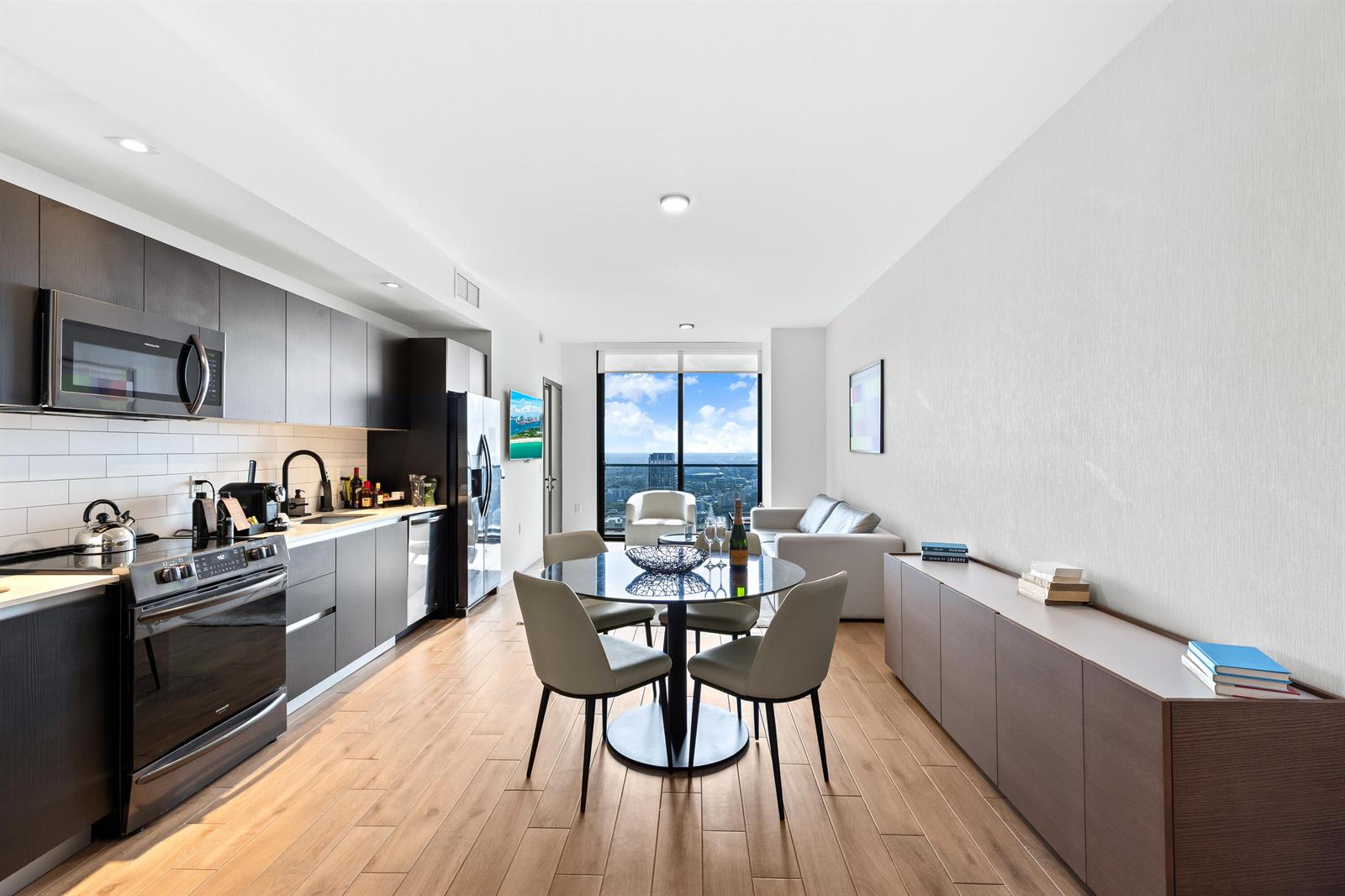 A modern open-concept apartment features a kitchen, dining area, and living space with floor-to-ceiling windows — 398 NE 5th Street # 4618, Miami FL 33132, MIAMI, FL