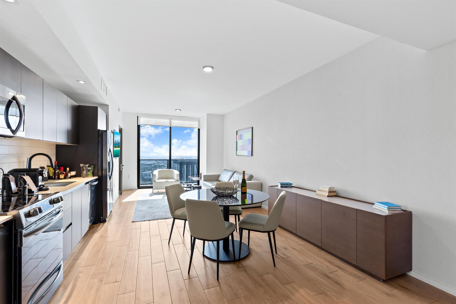 A modern apartment features an open-concept kitchen, dining area, and living space with floor-to-ceiling windows — 398 NE 5th Street # 4618, Miami FL 33132, MIAMI, FL