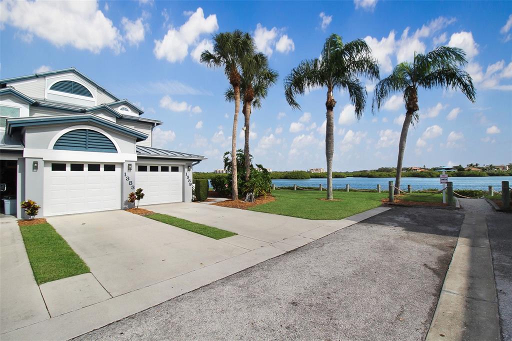 A two-story house with a two-car garage sits beside a lawn and a waterfront view — 1389 SIESTA BAYSIDE DRIVE UNIT 1389-F, SARASOTA, FL