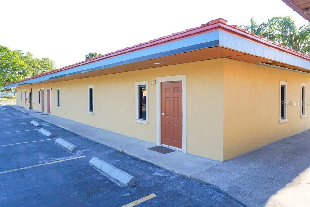 A single-story commercial building with yellow stucco walls, a brown door, and a parking lot — 5205 26TH STREET W, BRADENTON, FL