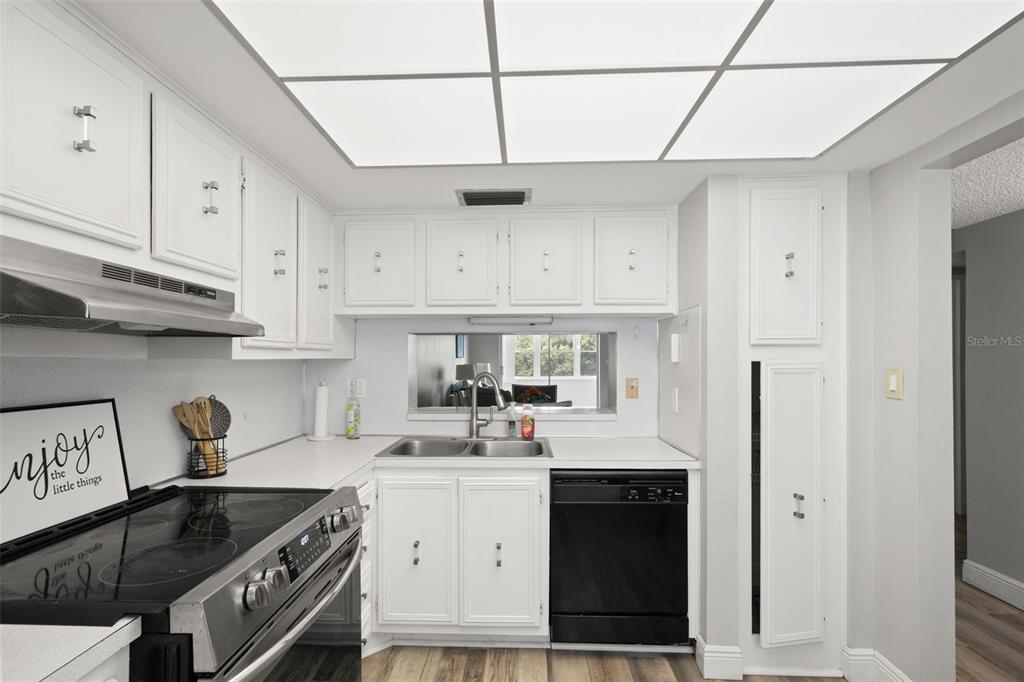 A kitchen with white cabinets, a black dishwasher, a stainless steel stove, and recessed lighting — 7321 CENTRAL AVENUE UNIT 407, ST PETERSBURG, FL