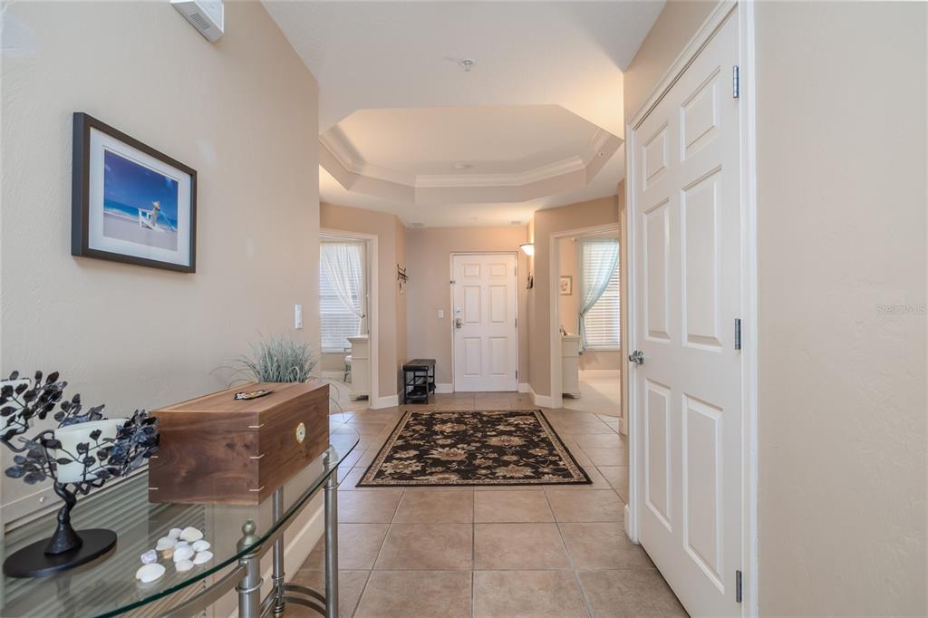 A tiled entryway features a tray ceiling, a patterned area rug, and a glass console table — 2403 S ATLANTIC AVENUE UNIT 604, DAYTONA BEACH, FL