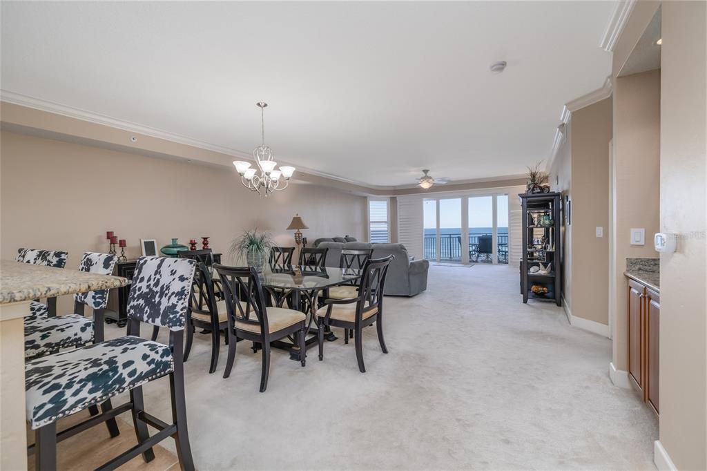 An open-concept living and dining area features a glass-top table, cow-print chairs, and ocean views — 2403 S ATLANTIC AVENUE UNIT 604, DAYTONA BEACH, FL