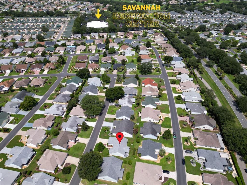 An aerial view shows a residential neighborhood with a marked house and recreation center — 2707 LA POSADA DRIVE, THE VILLAGES, FL