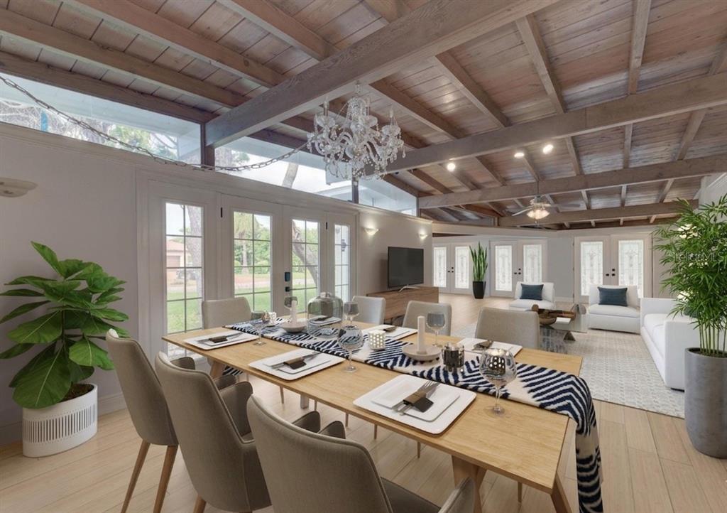 A dining area with a wooden table and exposed beam ceiling opens into a living room — 315 PARK BOULEVARD S, VENICE, FL