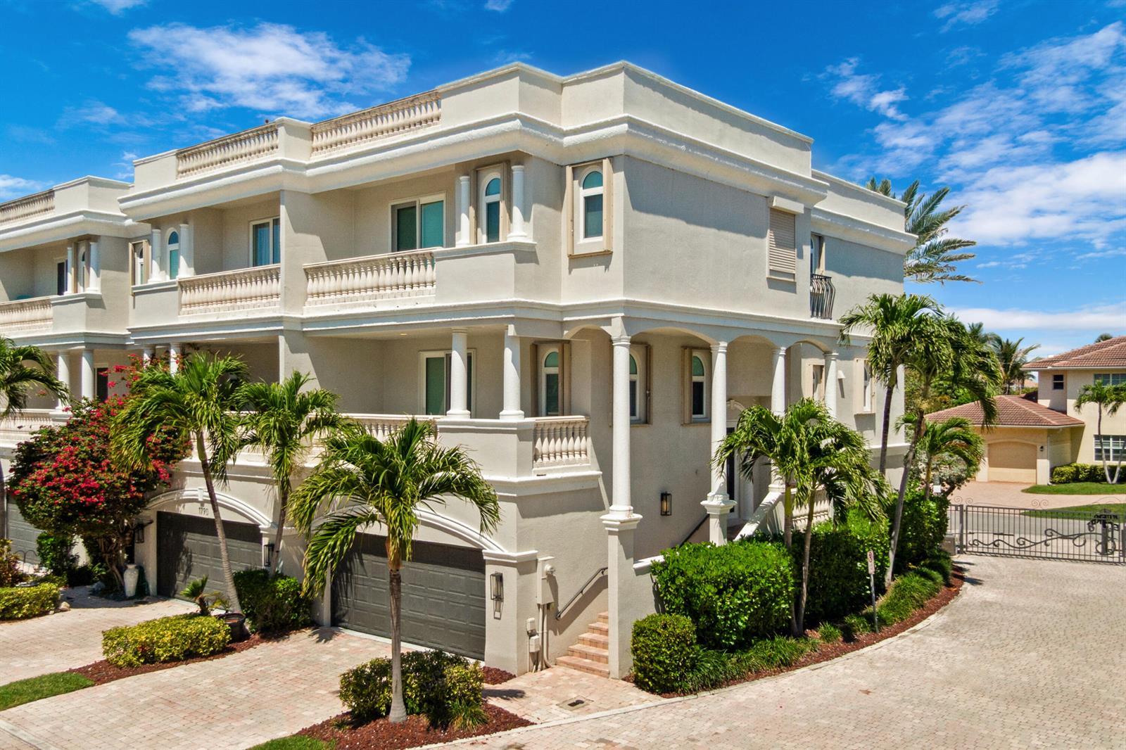 A three-story beige stucco house with a multi-car garage and palm trees in the front — 1792 Bay Drive # 27, Pompano Beach FL 33062, POMPANO BEACH, FL