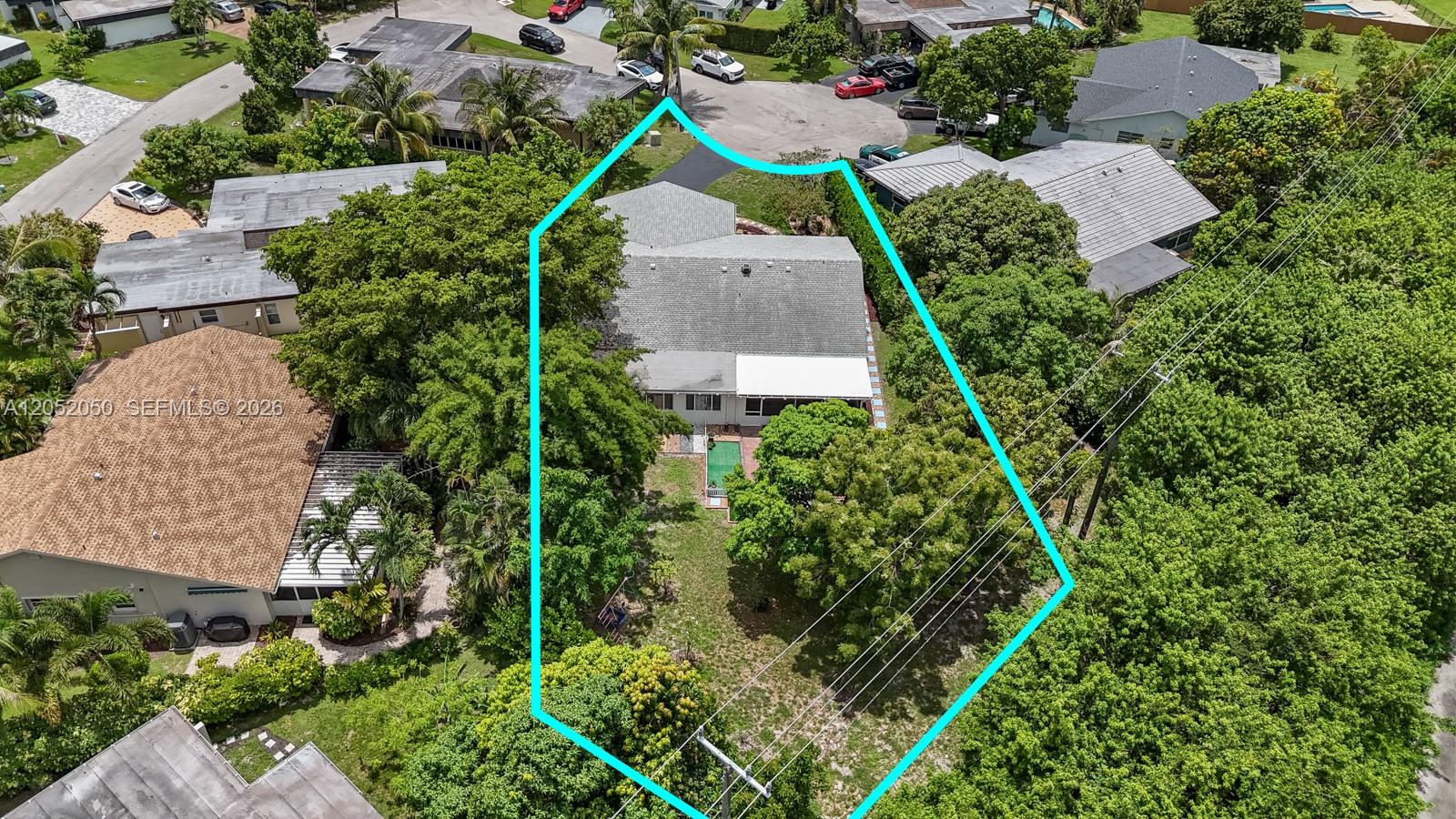 An aerial view shows a residential house with a large backyard and surrounding trees — 6307 Silk Oak Cir, Tamarac FL 33319, TAMARAC, FL