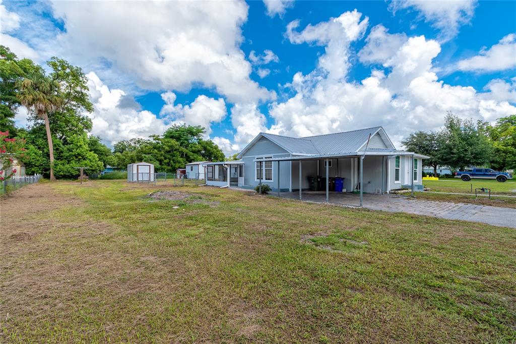 An open-concept living area features light wood-look flooring, recessed lighting, and a kitchen with gray cabinets — 1812 KENTUCKY AVENUE, ST CLOUD, FL