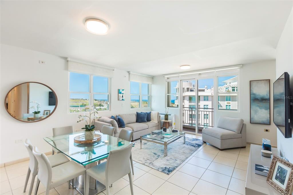 A bright living and dining area features tile floors, a glass table, and balcony access — Cond Capitolio Plaza CALLE DEL MUELLE UNIT 21007, SAN JUAN, PR