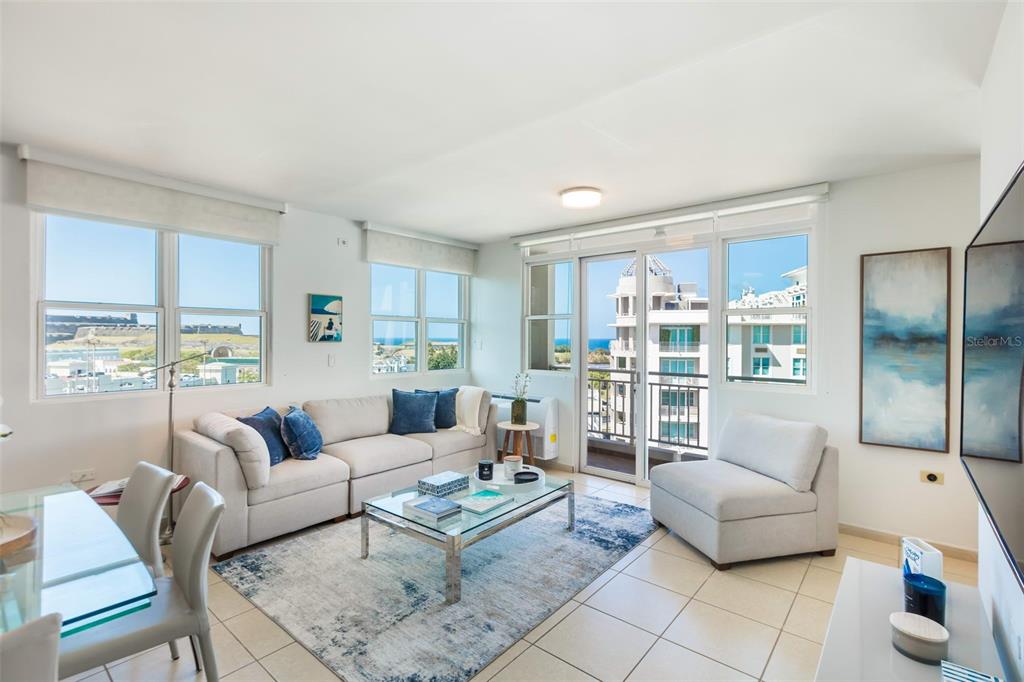 A bright living room features a beige sectional, glass coffee table, and a balcony view — Cond Capitolio Plaza CALLE DEL MUELLE UNIT 21007, SAN JUAN, PR